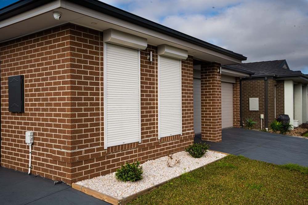 Two Beige roller shutter on red bricks wall